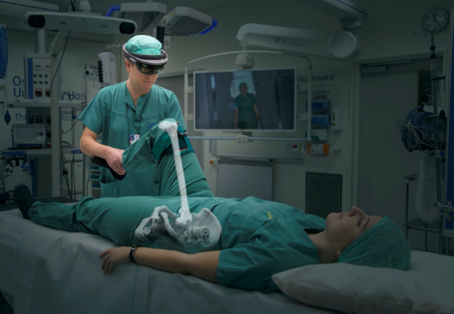 Illustrasjon av bruk av utstyr. Mann har på seg briller og ser skjelettet inni pasienten som 3D modell.